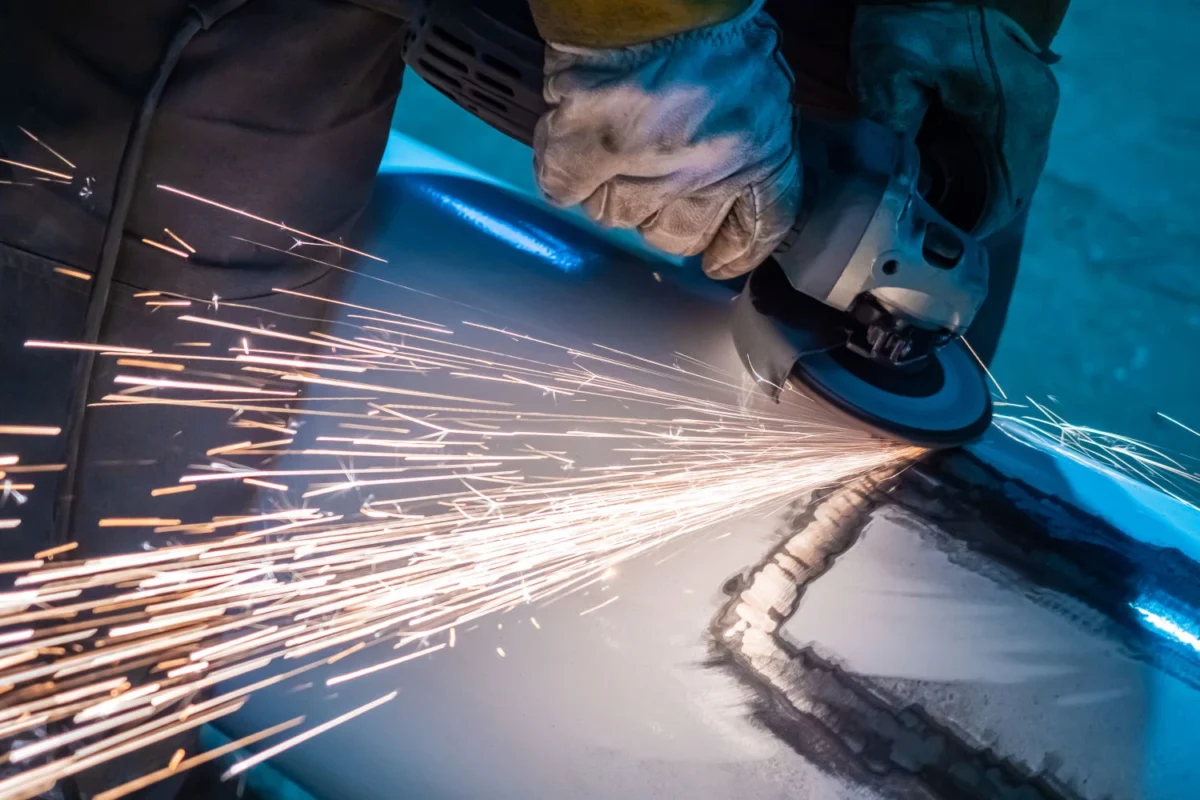 Abtragsschleifen einer Schweißnaht mit Fiberscheibe auf einem Metallblech